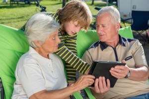 Grandson and his grandparents using digital tablet