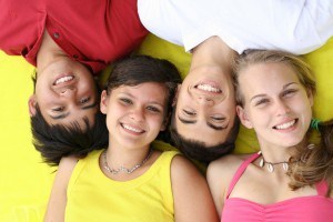 group of teens laying down smiling.